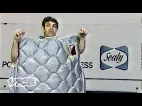 Performer holding a large silver quilted costume piece